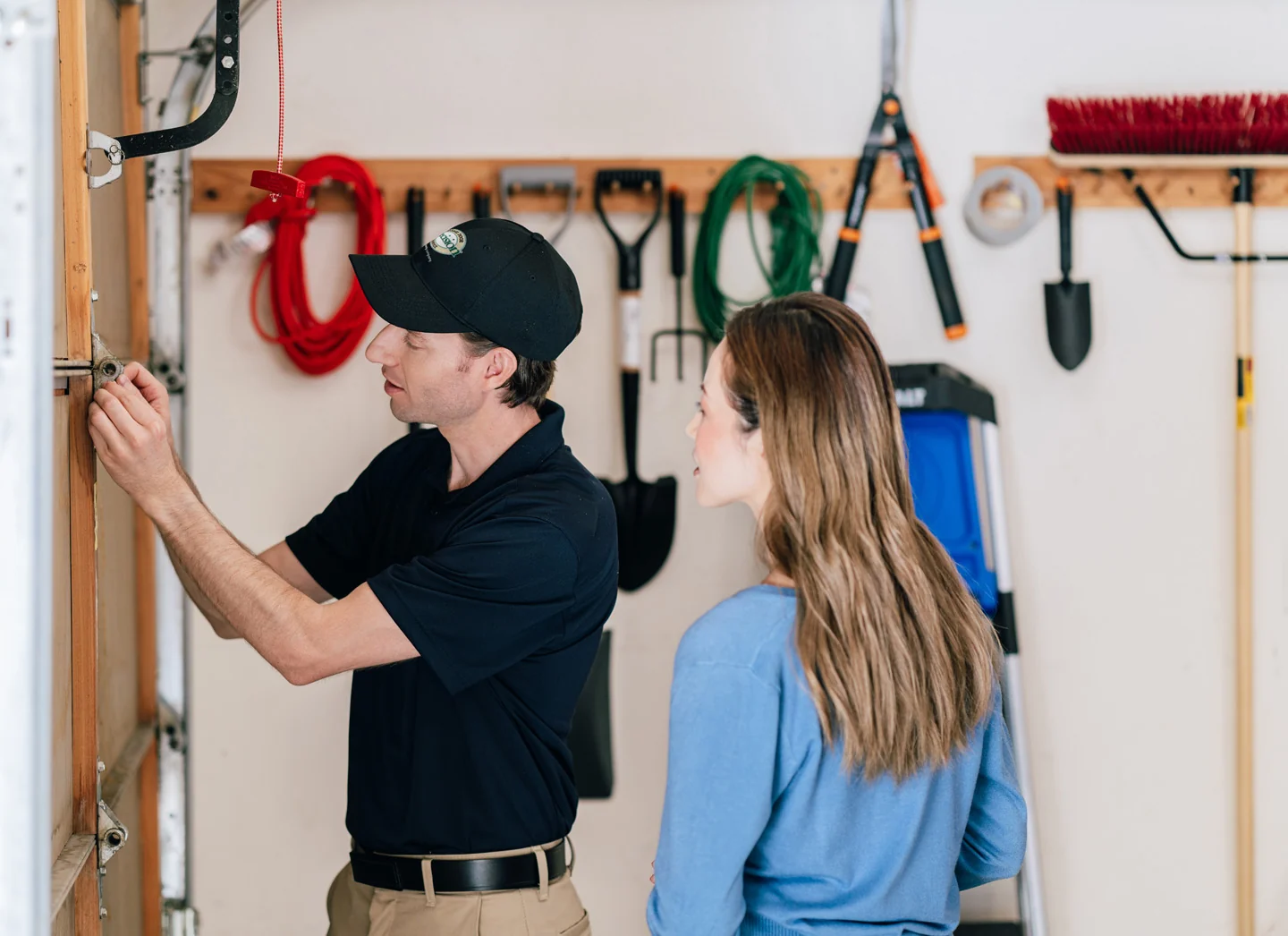 Precision technician inspecting a garage door and discussing garage door replacement cost